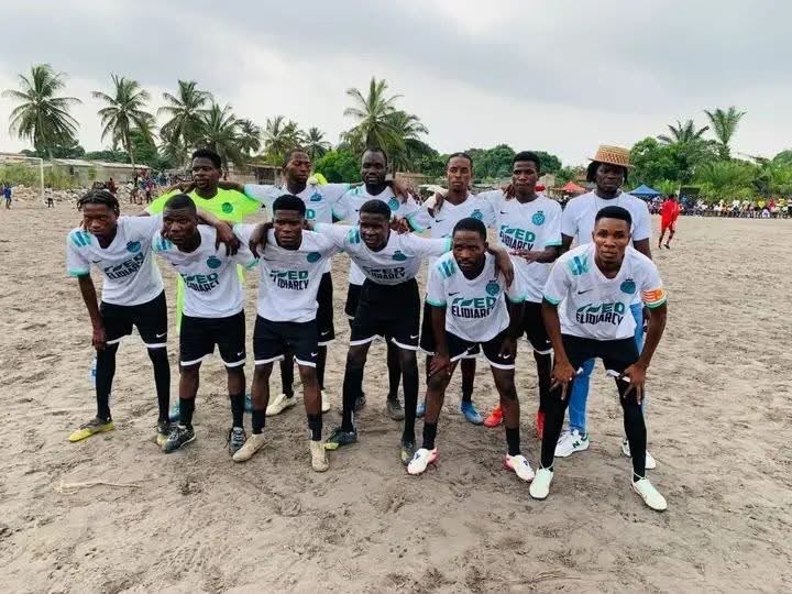 Equipa masculina posando em campo de areia