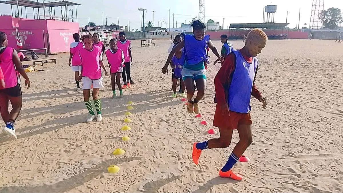 Atletas em treino no campo de areia